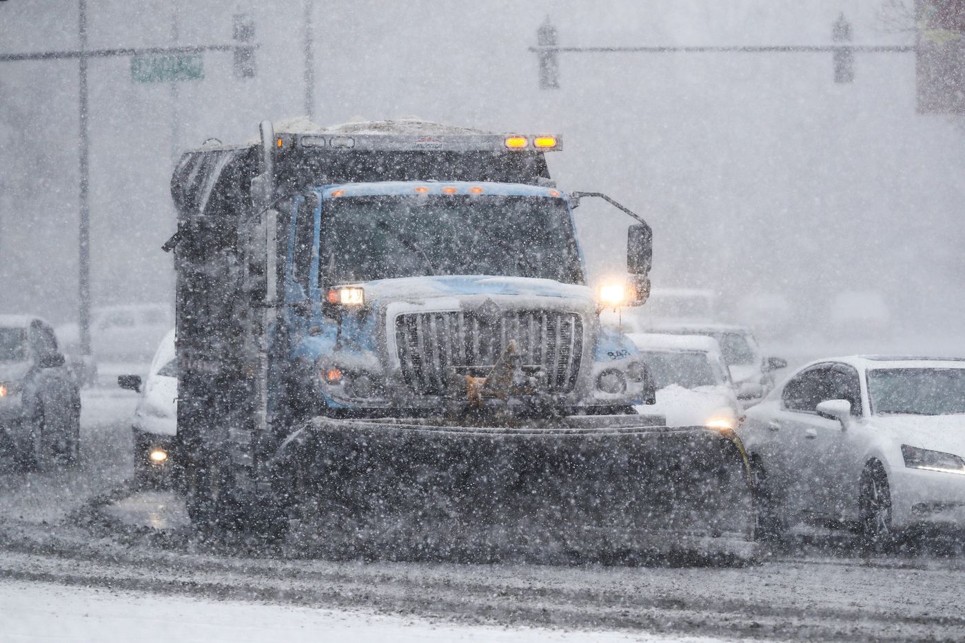 A snow plow heads east on West Logan Boulevard approaching North Milwaukee Avenue in Chicago's Logan Square neighborhood as a heavy snow comes down March 15, 2021.